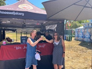 Supervisor Rice and Sackett cheers their drinks in front of Mossed Juicery stand with business owner