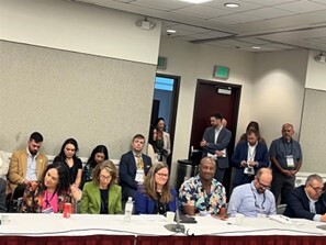 Group of Supervisors sitting at conference table, Supervisor Sackett and Supervisor-Elect Colbert smiling toward camera