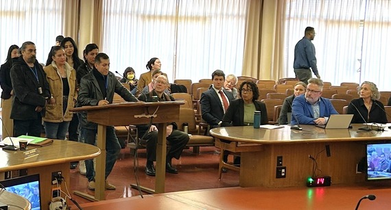 A man speaks into a microphone during a Board of Supervisors meeting.