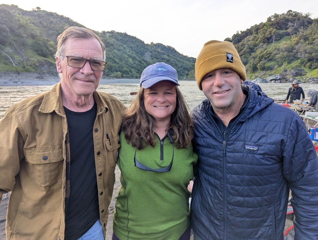 mary and two gentlemen smiling in front of Eel River