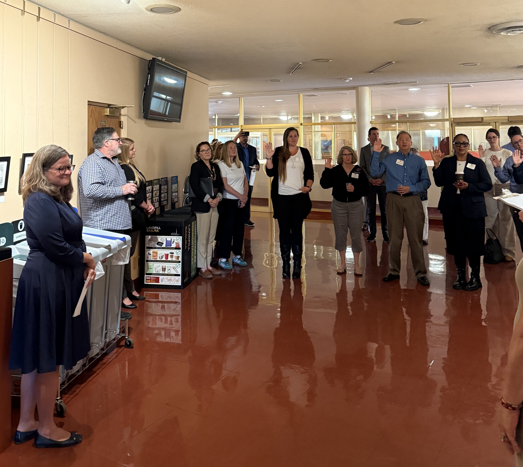Commissioners taking oath in Board lobby with staff and Supervisors present around them