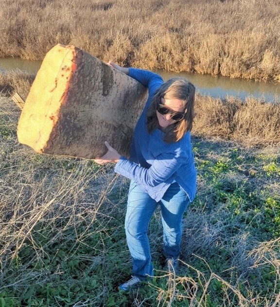 Mary carries Styrofoam out of creek