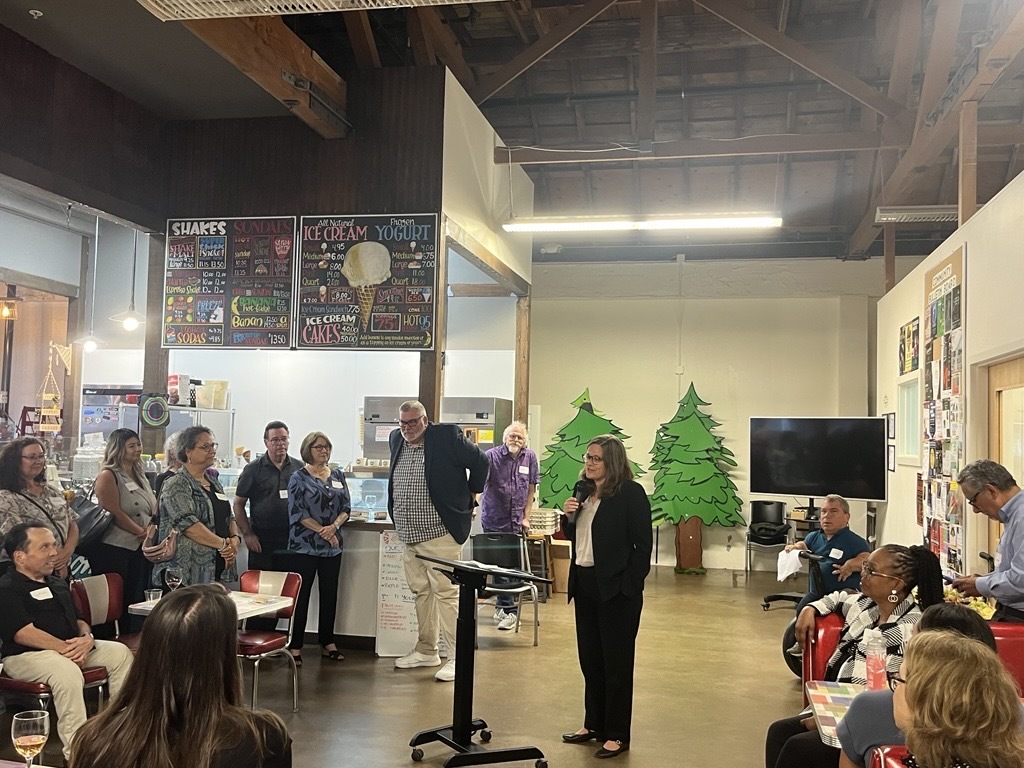 Mary speaking to crowd at Autistry studios