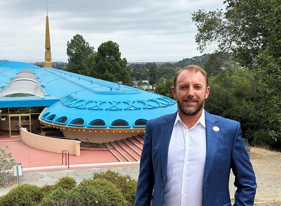 Christopher Blunk stands on a hill with the Marin County Civic Center behind him.