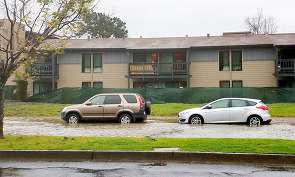 Two parked cars are sitting in several inches of water during a king tide surge.