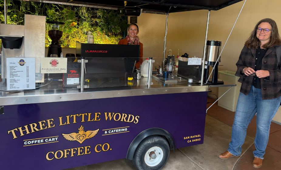mary smiling in front of three little words coffee co