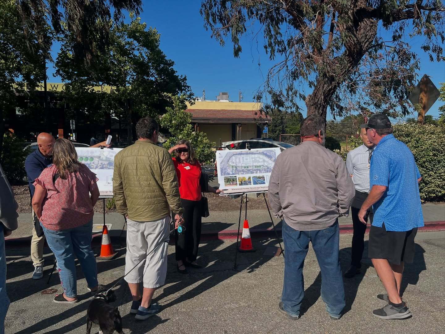 Photo of people next to a poster on an easel