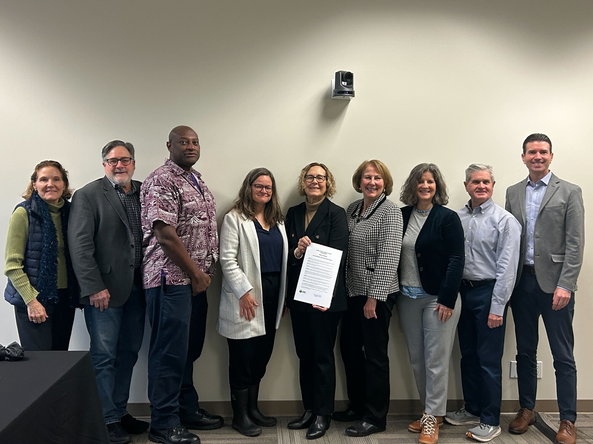 Marin Transit Board of Directors standing alongside Nancy Whelan who is holding a resolution