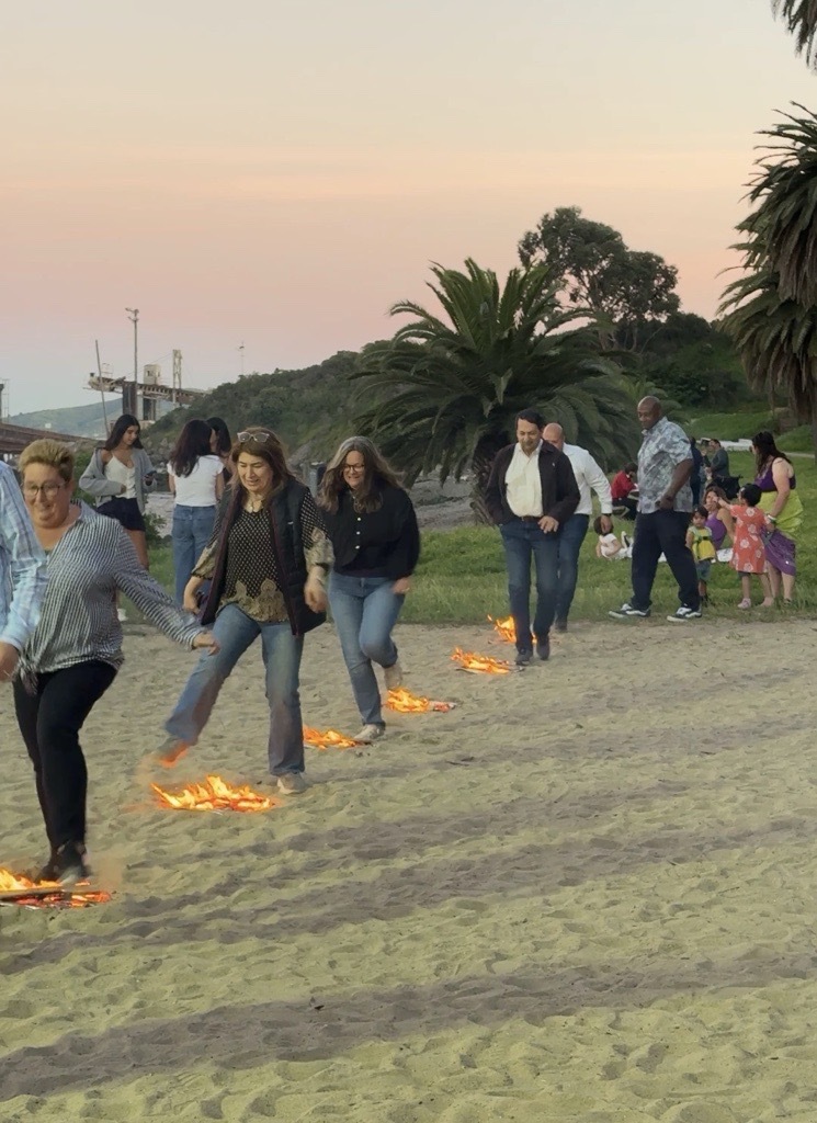 Mary and other jumping over small fires in sand on McNears beach