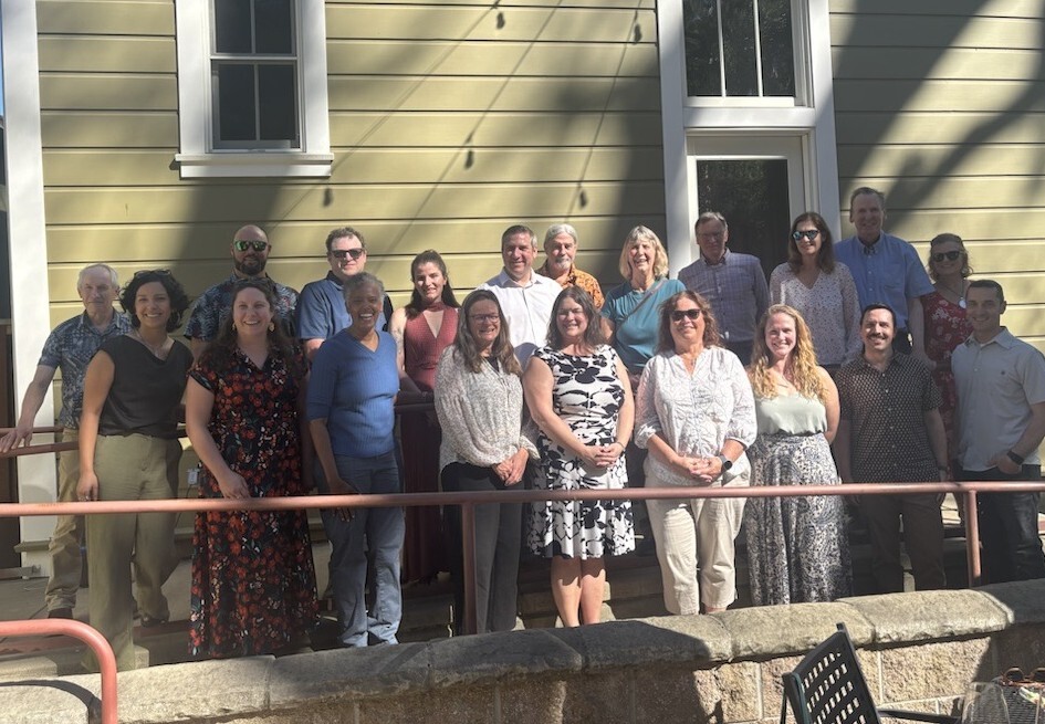 group photo smiling in front of building facade