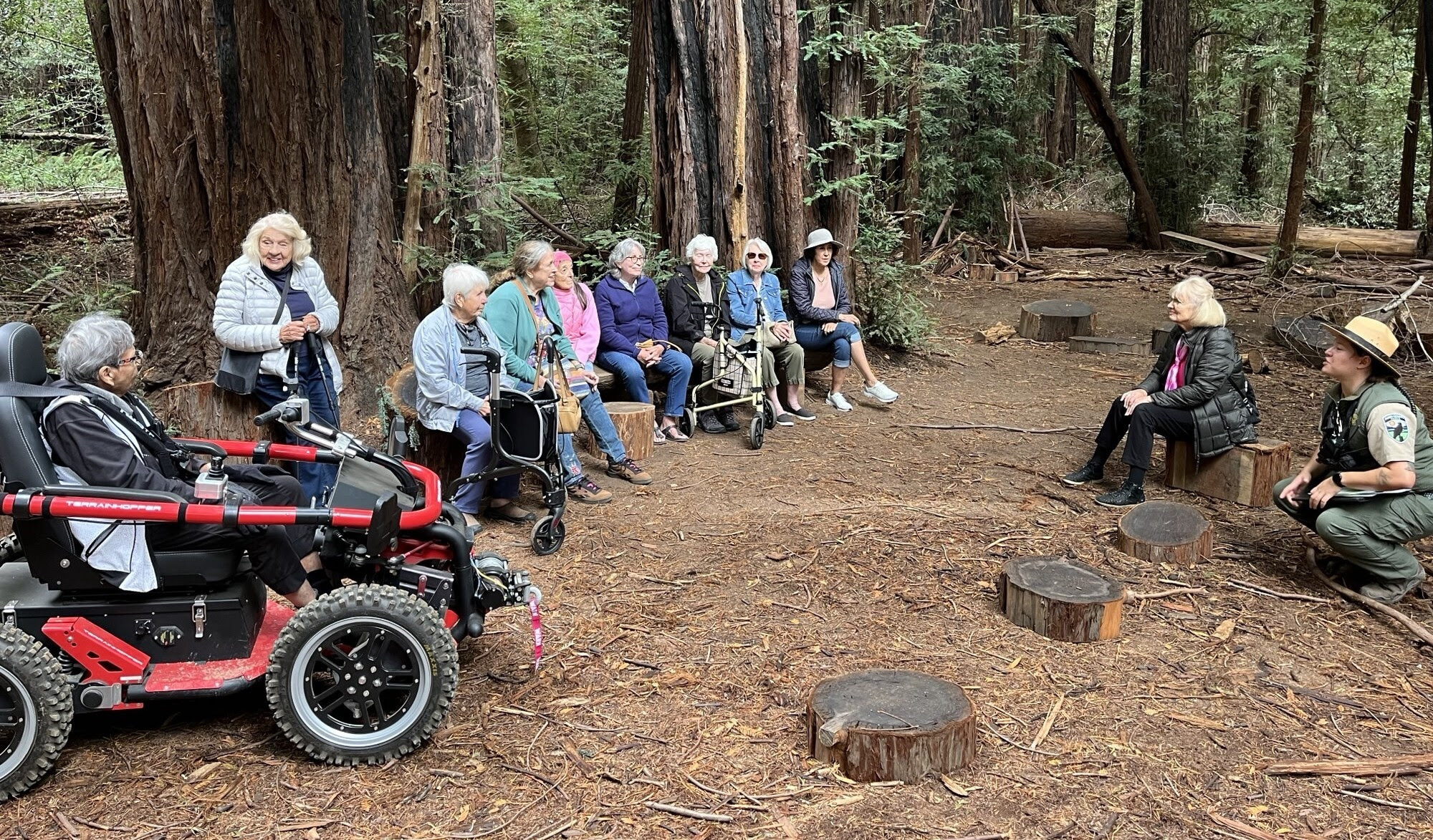 Group of people in the forest at Roy's Redwoods, one in terrain hopper on side