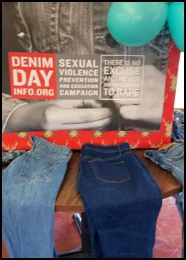 Jeans on a table in front of a denim day poster