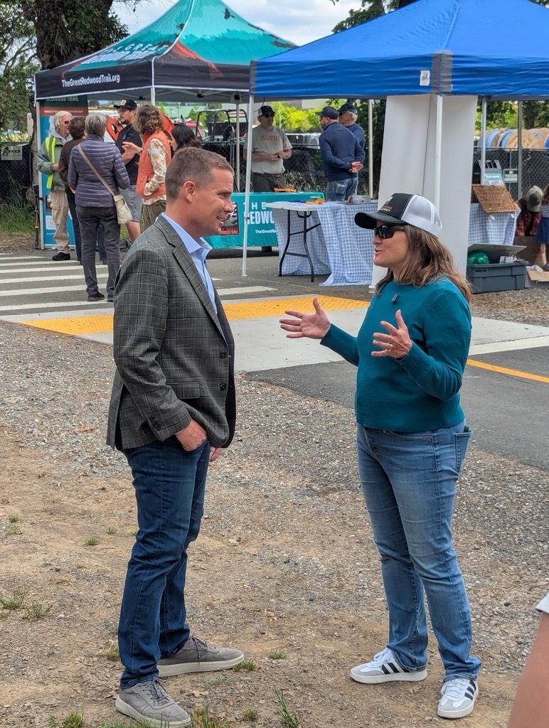 Senator McGuire and Mary Sackett standing beside vendor tents
