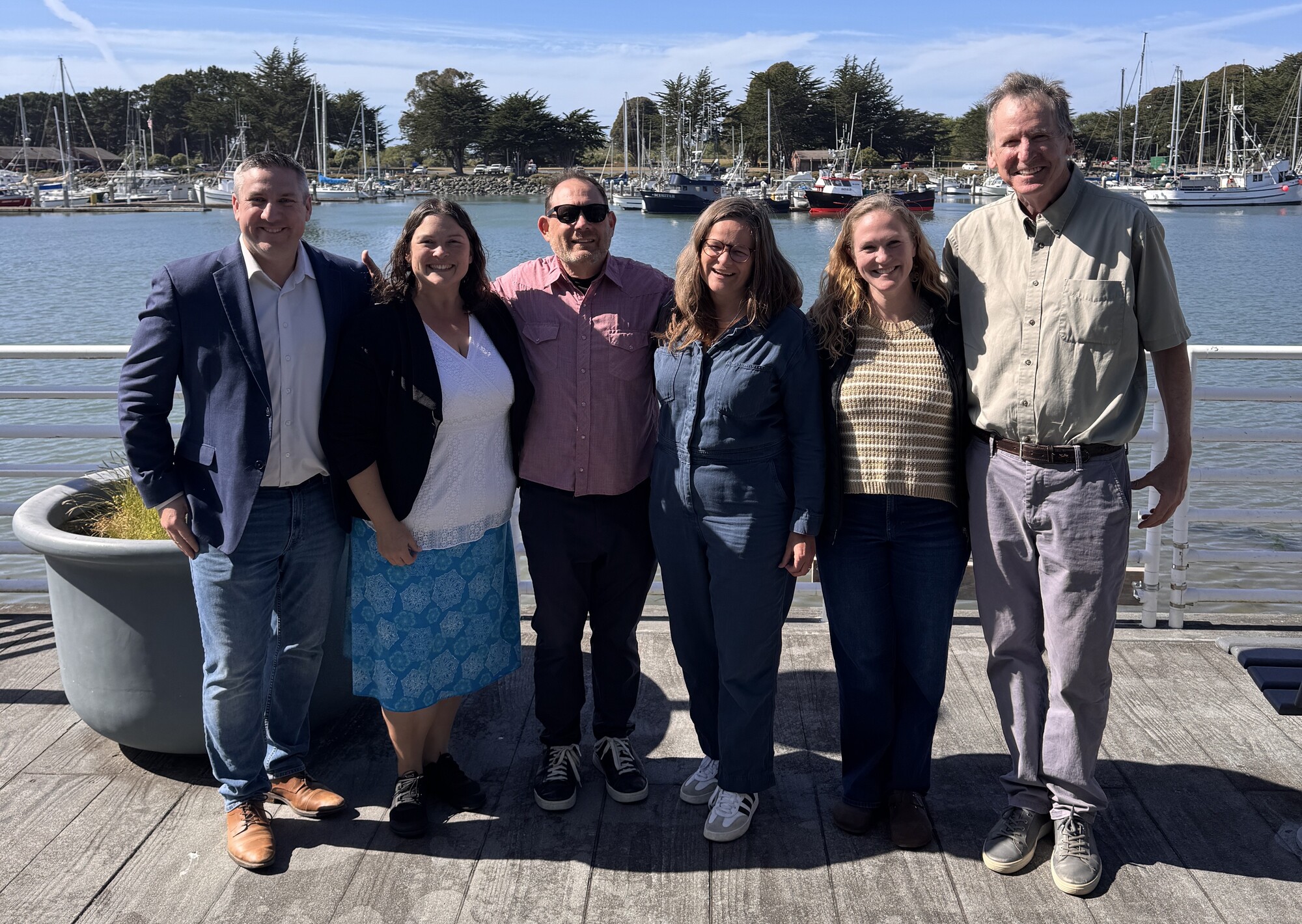 GRTA staff and board in front of Bay with boats in background