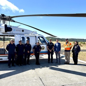 Supervisor Lucan with Marin County Fire staff in front of firefighting helicopter. 