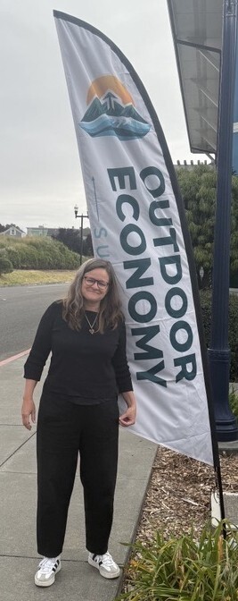 Mary with Outdoor Economic Summit Banner
