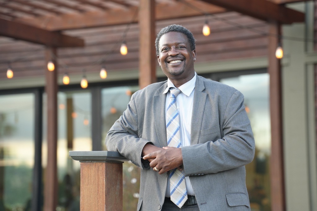 Smiling portrait of Marlon Washington on an outdoor patio