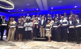 About 40 people smile and pose on stage with their Digital Counties Survey awards.