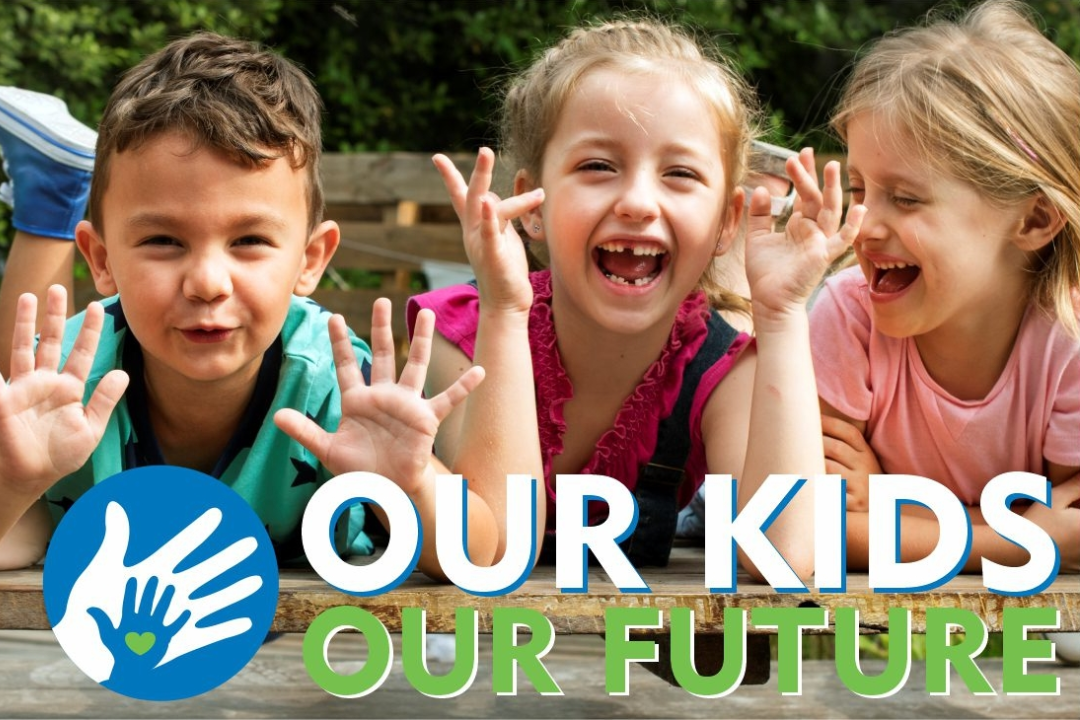 Children laughing and holding up hands