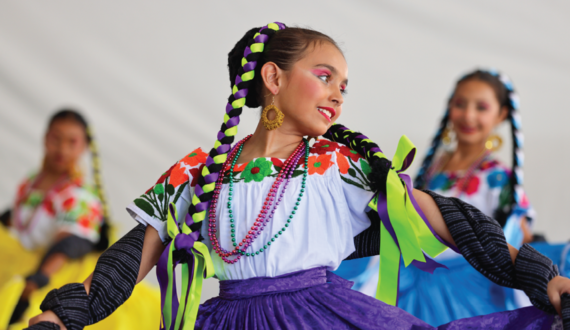 A young woman twirls her skirt while dancing.