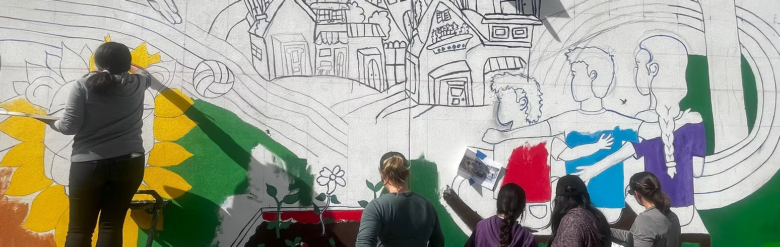  people painting a mural with yellow and green paint