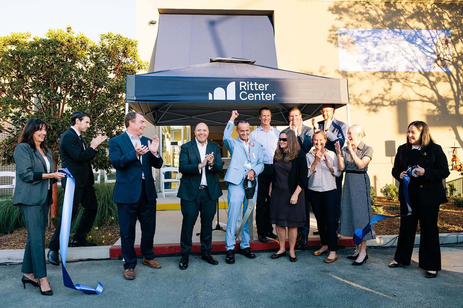 group shot post cutting ribbon in front of new building