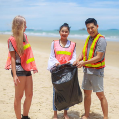 three teens picking up trash