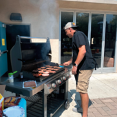 Staff member grilling food.