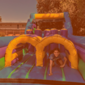 Teen on an inflatable obstacle course.
