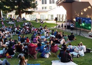 Audience Watching Outdoor Performance in Park