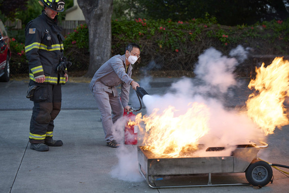 Man putting out fire with extinguisher during training as part of the Chinese Leadership Academy