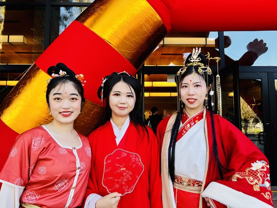 Three women dressed in traditional red wardrobes for Lunar New Year Celebration