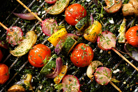 Vegetable skewers being cooked on an outdoor grill.
