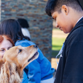 Teen hanging out with therapy dog.