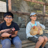 Two teens holding chickens.