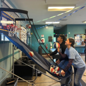 Teen and staff playing basketball