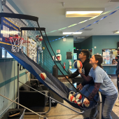 A teen and a staff member playing basketball.