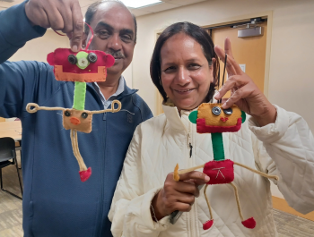 Two attendees showing off their dangly robot crafts from the Sewing with FabMo program
