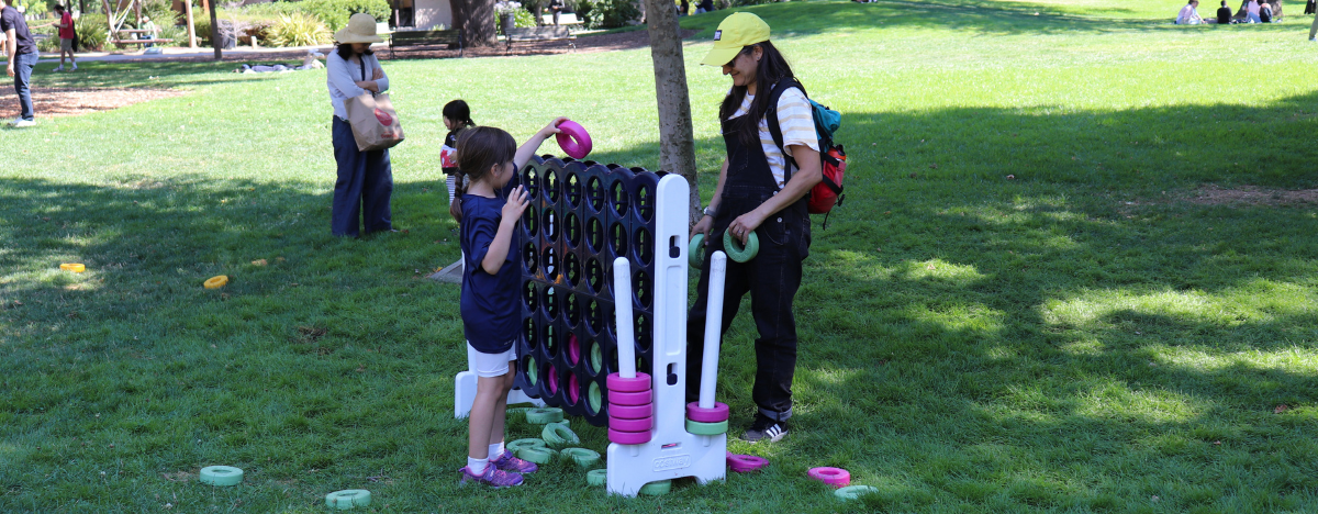 Photo of an adult and child playing a lawn game in Pioneer Park
