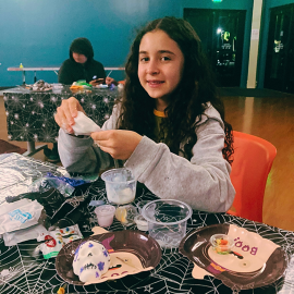 Teen making Halloween crafts.