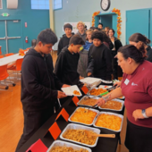 Teens in a food buffet line.