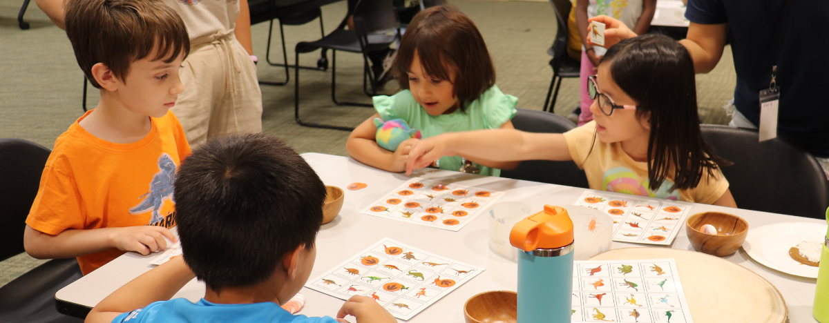 Photo of children playing dinosaur bingo at a STEAM Friday program
