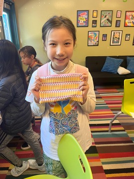 Teen holding up her craft project.