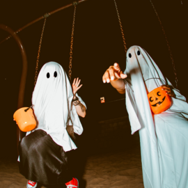 Two teens in ghost costumes.