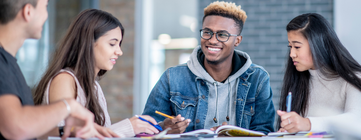 Photo of a happy group of teens doing homework together
