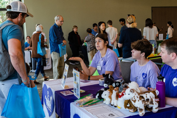 Image of people talking at a booth during the Fall Volunteer Fair