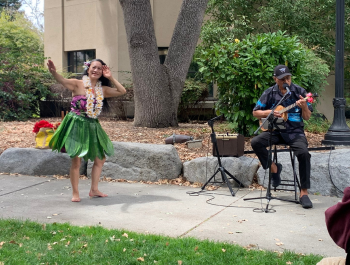 Photo of musical guests Haopinaka playing a ukulele and performing a hula dance