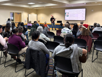 Photo of attendees practicing songs on the ukulele during the Winter Holiday Yule-kulele Jam program