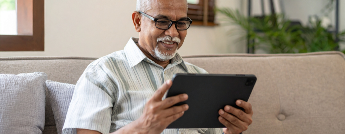 Photo of a senior reading a book on their tablet