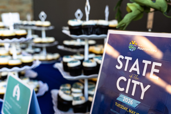 Pocture of desserts and the State of teh City program on blue tablecloth